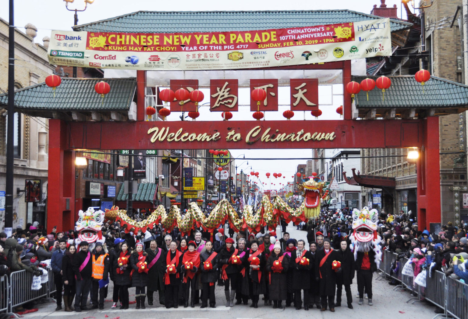 gateway-2-1536×1049 Parade participants posting in front of the Gateway in Chinatown (Chicago), holding a ceremonial dragon during the Chinese New Year Parade