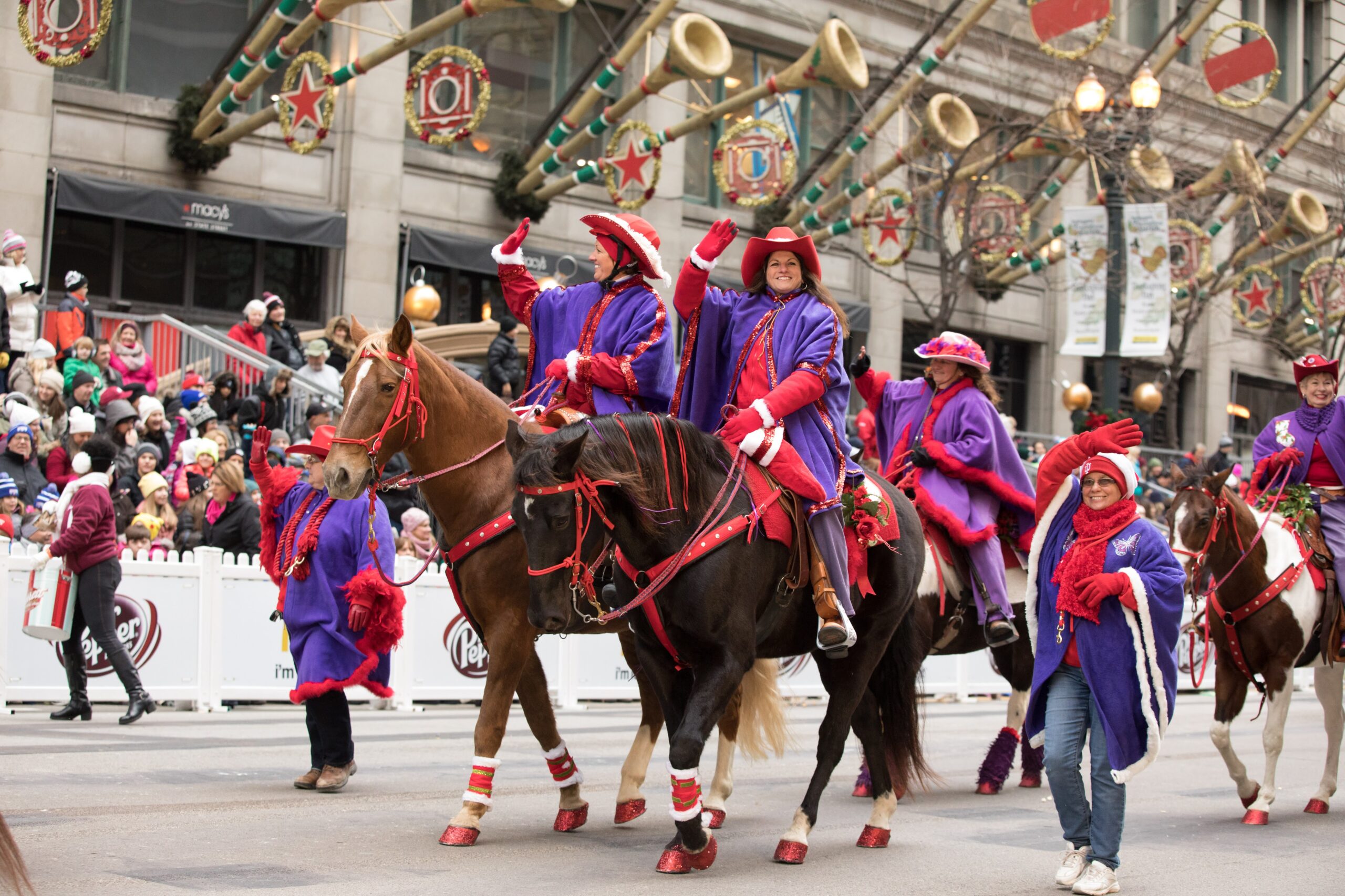 2016 Red Hats & Purple Chaps (14) Several members (and their horses) of the Red Hats and Purple Chaps Equestrian Group marching in the 2016 Chicago Thanksgiving Parade. The ladies are adorned with red hats and purple coats.