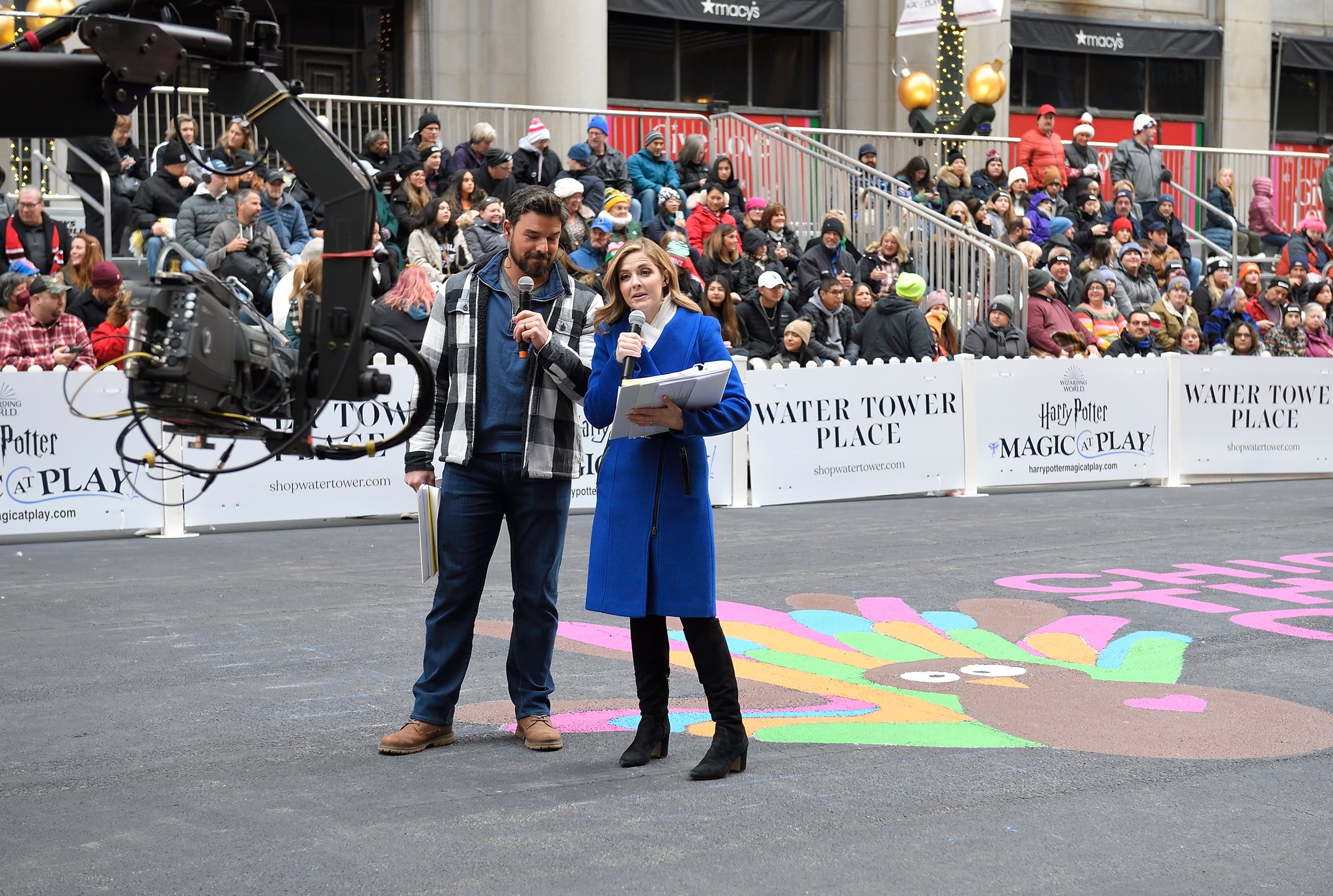 Jen and Jesse 2022 Jesse Hutch and Jen Lilly speaking into the camera during the 2022 Chicago Thanksgiving Parade.