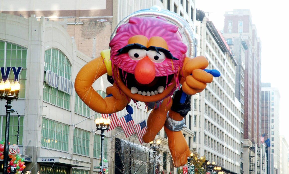A helium-inflated Animal balloon (from The Muppets) floats over State Street during the Chicago Thanksgiving Parade