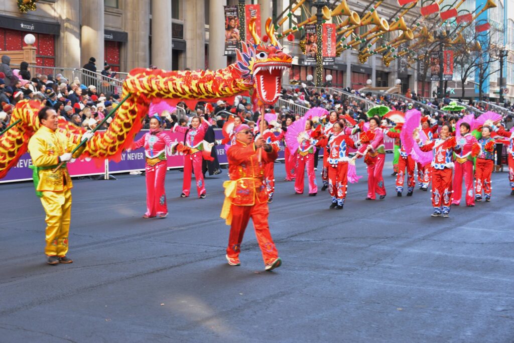 The Chicago Chinese Culture & Arts Society performs with male dragon dancers (with dragon) in foreground, and female dancers in back.
